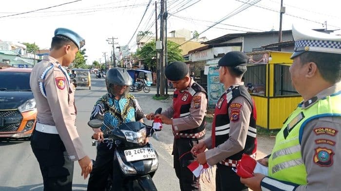 polres_tapteng_bagikan_bendera_merah_putih_ajak_masyarakat_rayakan_hut_ke80_ri