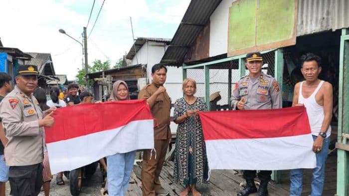 polres_pelabuhan_belawan_bagikan_bendera_merah_putih_ke_warga_yang_belum_memasang