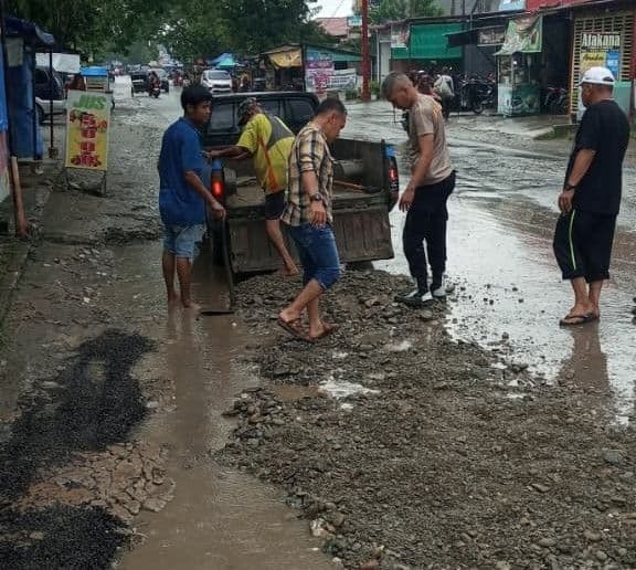 warga_tanjung_pura_perbaiki_sendiri_jalan_merdeka_yang_rusak