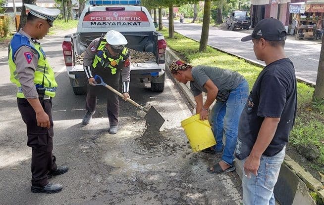 peduli_keselamatan_polisi_di_langkat_gotong_royong_perbaiki_jalan_rusak