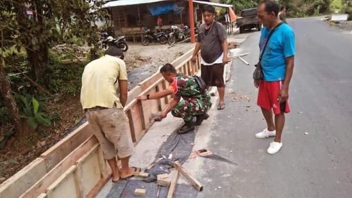 babinsa_bersama_warga_bonan_dolok_bangun_pembatas_jalan