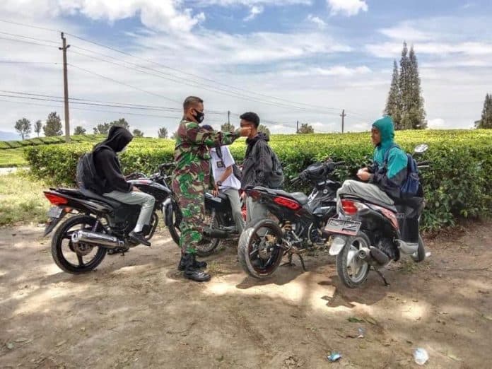 babinsa_imbau_pengunjung_wisata_kebun_teh_sidamanik_patuhi_prokes