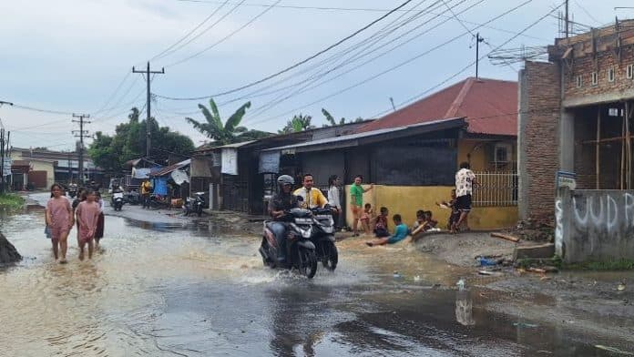 banjir_di_klambir_lima_jadi_wahana_bermain_anak_anak