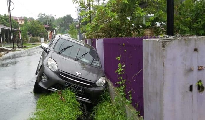 banjir_di_viyata_yudha_siantar_satu_mobil_terperosok_ke_parit