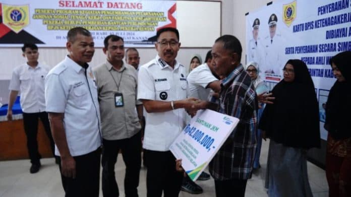 bupati_labusel_serahkan_1000_kartu_bpjs_pekerja_rentan_tahun_2024