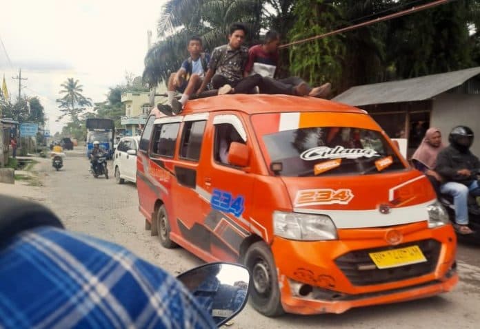 fokus_lensa_angkutan_umum_menaikkan_penumpang_di_atap