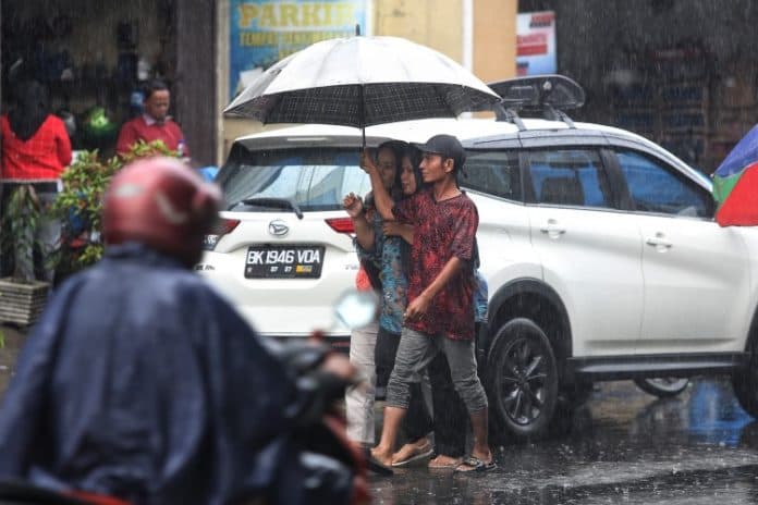 fokus_lensa_ojek_payung_menampung_rezeki_di_musim_hujan