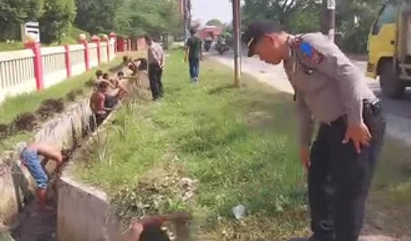 geng_motor_dihukum_bersihkan_parit_depan_mapolsek_beringin