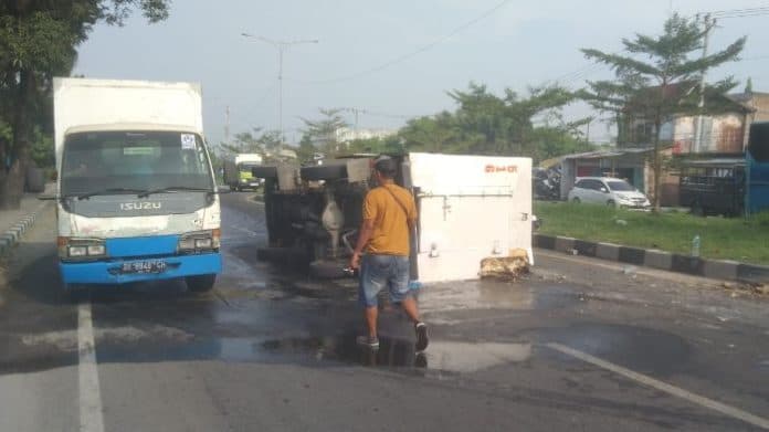 hindari_sepeda_motor_menyalip_mobil_bawa_es_kristal_terbalik_di_medan