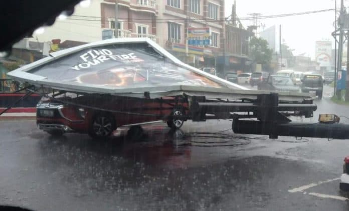 hujan_disertai_angin_kencang_papan_reklame_timpa_mobil_di_siantar