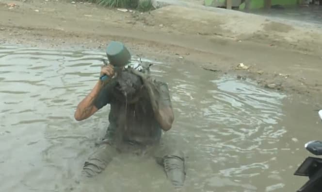 jalan_rusak_warga_cuci_motor_dan_mandi_lumpur_di_asahan