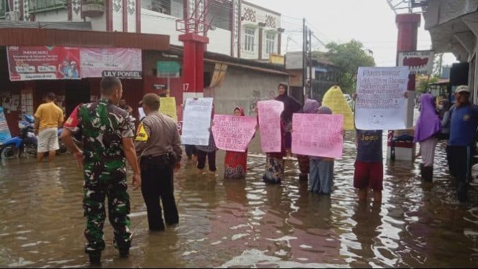 kerap_banjir_puluhan_ibu_ibu_beraksi_di_tengah_jalan_marelan