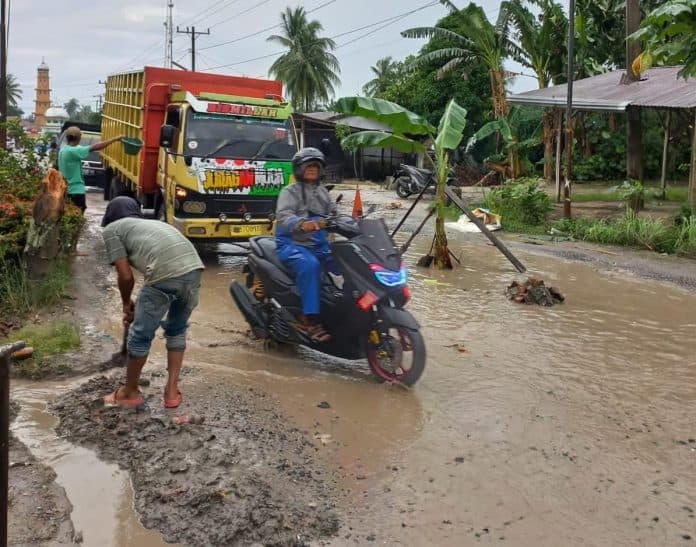 kesal_warga_asahan_tanam_pohon_pisang_di_tengah_jalan_rusak