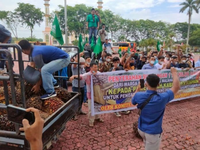 minta_perbaiki_jalan_rusak_di_asahan_warga_demo_bawa_1_ton_sawit