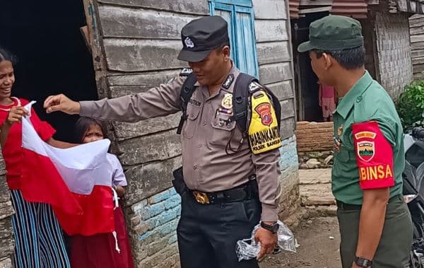 momen_bhabinkamtibmas_polresta_deli_serdang_bagikan_bendera_merah_putih_ke_warga