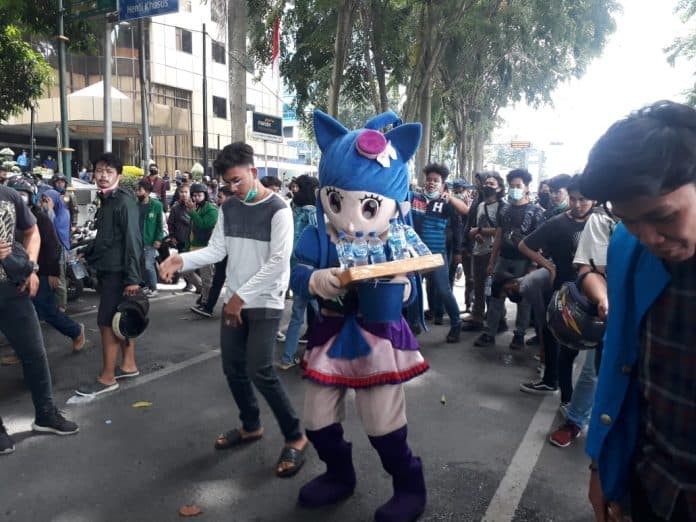 pedagang_ini_sengaja_pakai_baju_badut_di_tengah_demo_coba_tebak_tujuannya