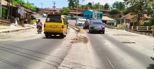 pintu_keluar_masuk_sidikalang_dihiasi_jalan_berlubang_dan_ceceran_material_pengguna_jalan_mengeluh