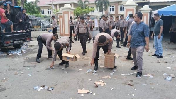 polisi_kutip_sampah_pengunjuk_rasa_di_depan_pn_lubuk_pakam