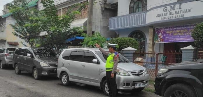 polres_tanjungbalai_atur_arus_lalin_di_sejumlah_gereja_saat_ibadah_tahun_baru