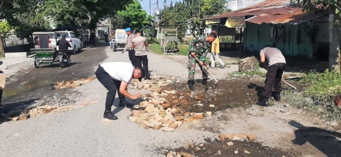 polsek_dan_koramil_pantai_cermin_lakukan_penimbunan_jalan_provinsi_yang_berlubang