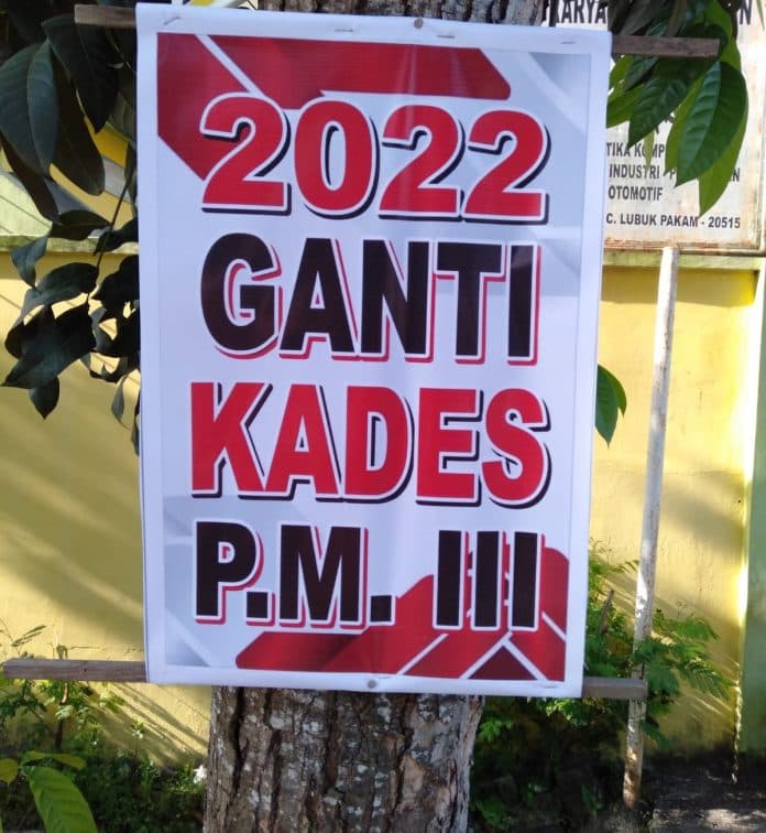 poster_bertuliskan_2022_ganti_kades_pagar_merbau_iii_nempel_di_pohon