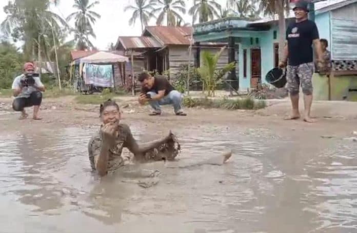 protes_jalan_rusak_warga_pematang_sei_baru_mandi_lumpur_di_tengah_jalan