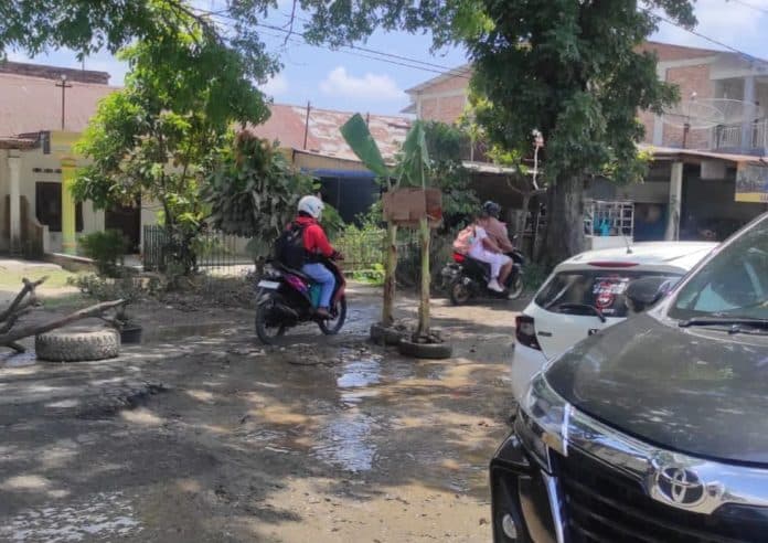 protes_warga_tanam_pohon_pisang_pada_lubang_di_jalan_asahan_simalungun