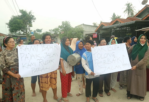 puluhan_emak_emak_di_asahan_bawa_panci_dan_poster_protes_jalan_rusak_parah