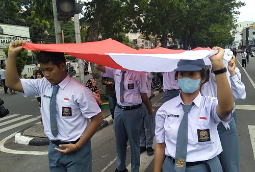 ratusan_peserta_bentangkan_bendera_merah_putih_sepanjang_15_km_di_medan