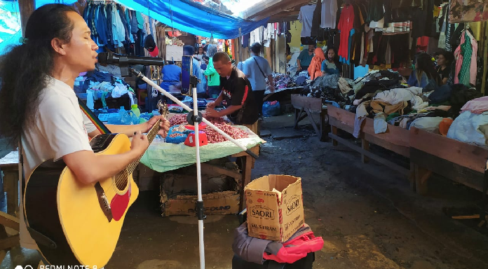 suara_merdu_musisi_jalanan_hilangkan_suasana_sepi_pasar