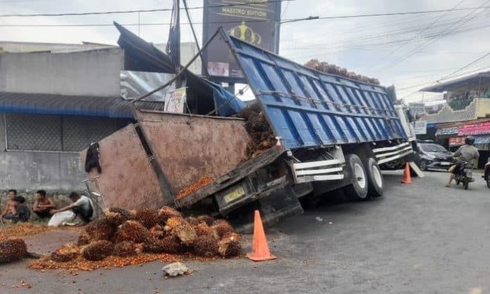 truk_bermuatan_kelapa_sawit_terperosok_di_saluran_air_jalan_narumonda_siantar