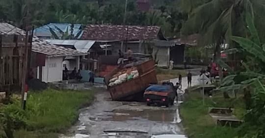 truk_bermuatan_kelapa_terperosok_di_jalan_rusak_lotu_nias_utara